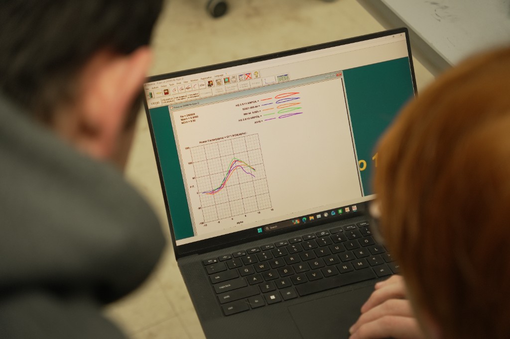 Team members reviewing wing airfoil analysis software on a laptop